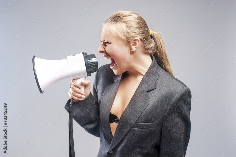 Caucasian Blond Woman Shouting Using Megaphone. Against Grey Caucasian Blond Woman Shouting Using Megaphone. Against Grey