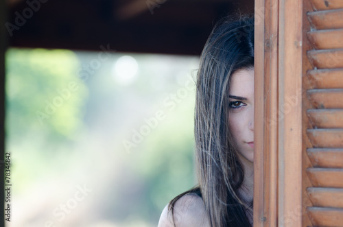 Lady looking out the window of a cabin