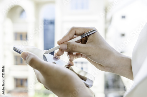 A woman using tablet with stylus pen