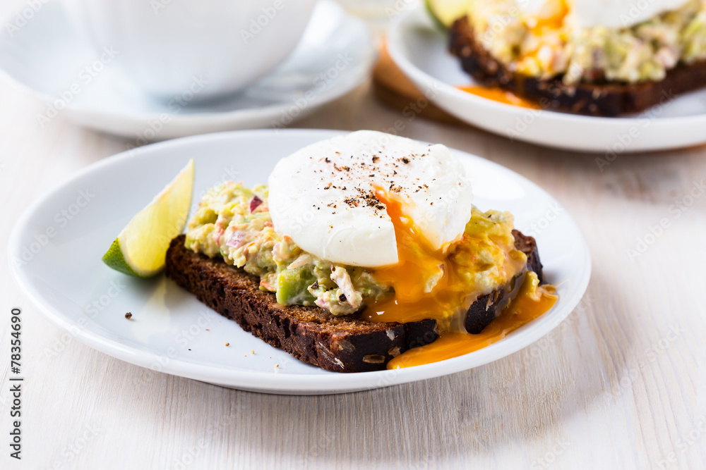 Avocado and feta smash on rye bread and poached egg on top Avocado and feta smash on rye bread and poached egg on top