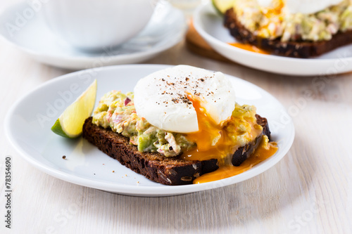 Avocado and feta smash on rye bread and poached egg on top