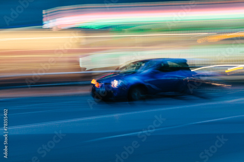 Blue Sports Car in a Blurred City Scene © SOMATUSCANI