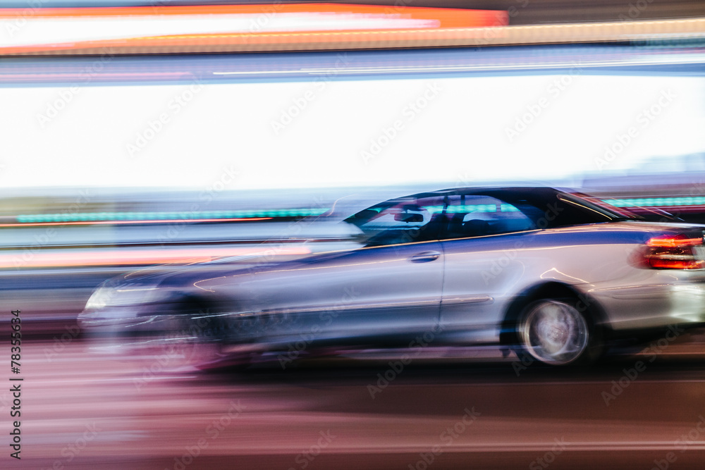 Grey Luxury Car in a Blurred City Scene