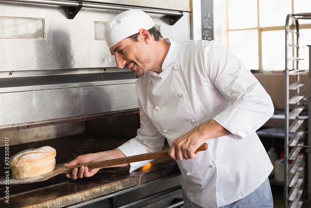 Happy baker taking out fresh loaf Happy baker taking out fresh loaf
