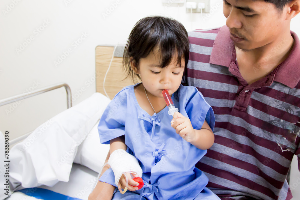 Sick little girl sit on her father and giving medicine syringe b Sick little girl sit on her father and giving medicine syringe b