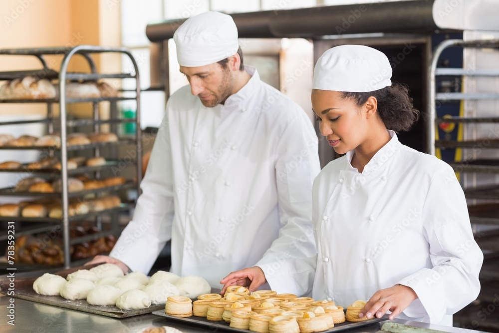 Bakers looking at trays of dough and pastry Bakers looking at trays of dough and pastry