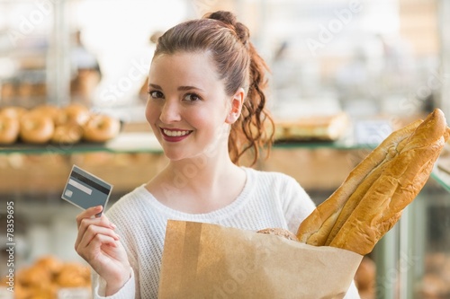 Pretty brunette with bag of bread and credit card photo