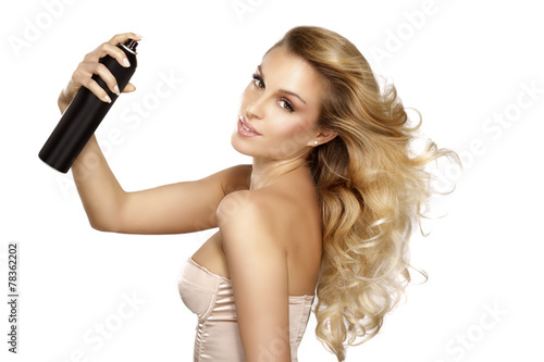 beautiful model applying spray on windy hair