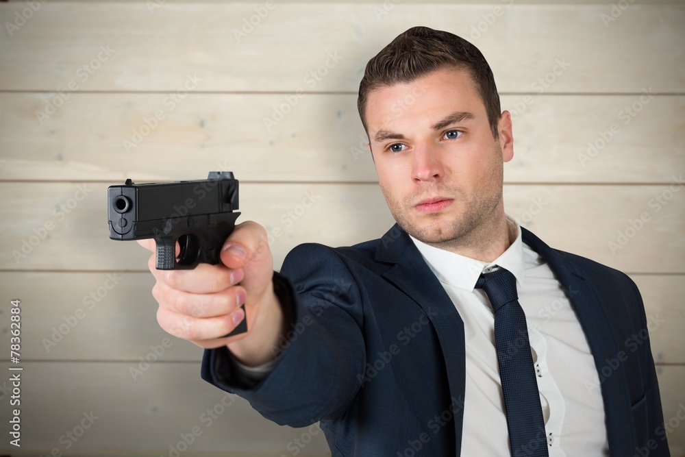 Composite image of serious businessman pointing a gun Composite image of serious businessman pointing a gun