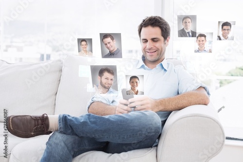 Cheerful man sitting on the couch using his smartphone