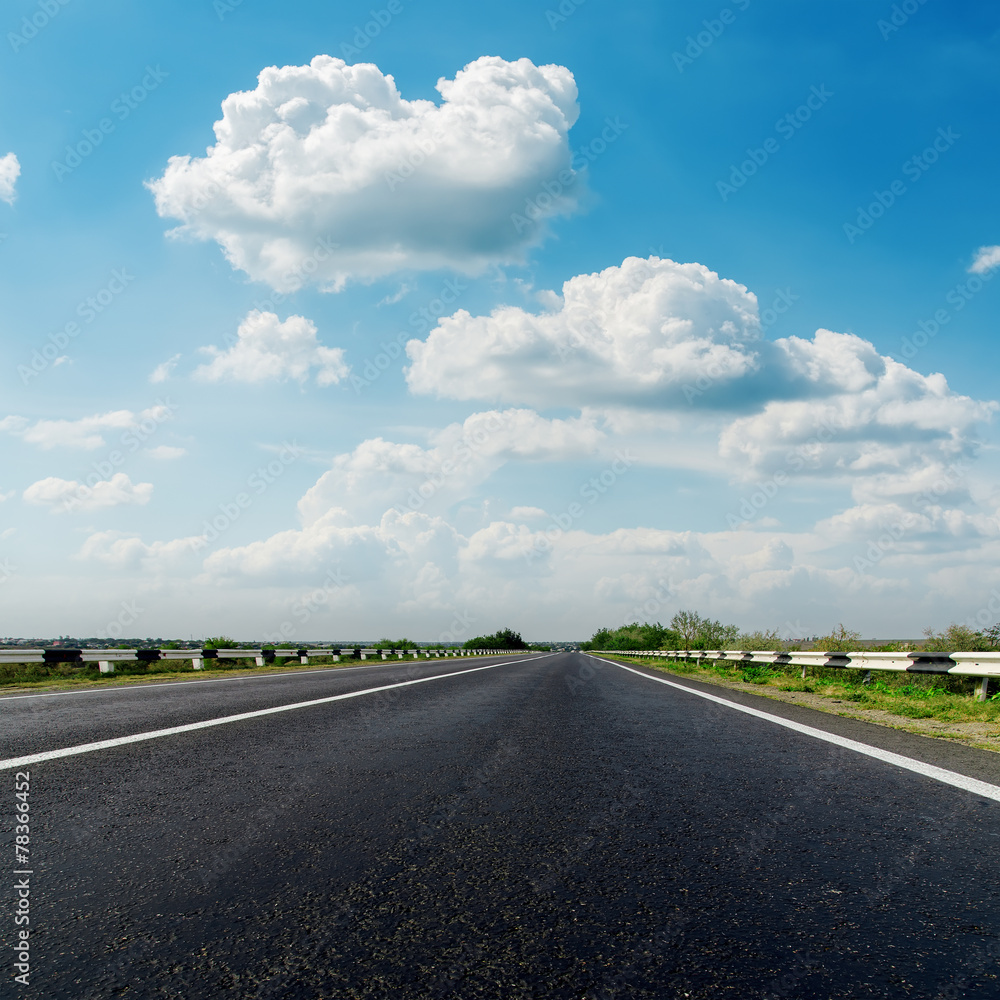 asphalt road closeup and low clouds in blue sky asphalt road closeup and low clouds in blue sky
