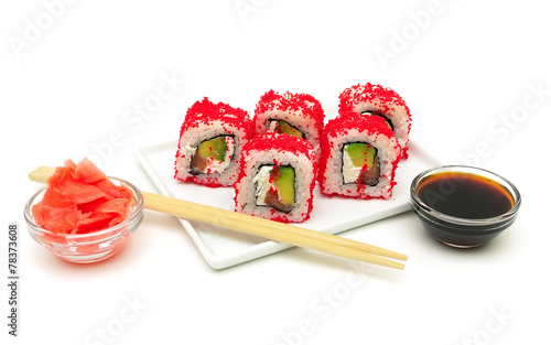 rolls with avocado, salmon and fish roe on a plate on a white ba
