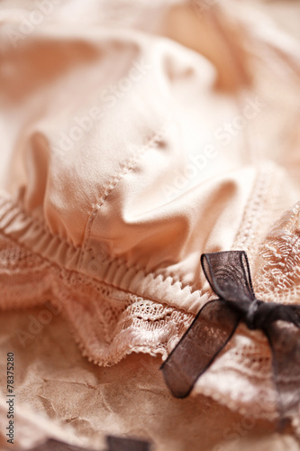 Tenderness peachys lingerie with candle and dry petals.