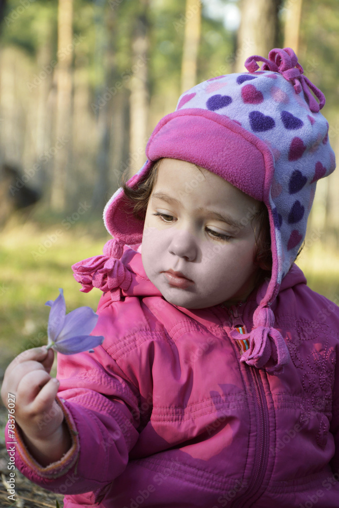 Little girl in the woods close look at a flower. Little girl in the woods close look at a flower.