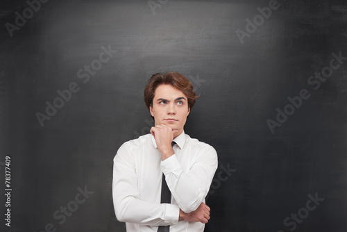 Thoughtful man on chalkboard background