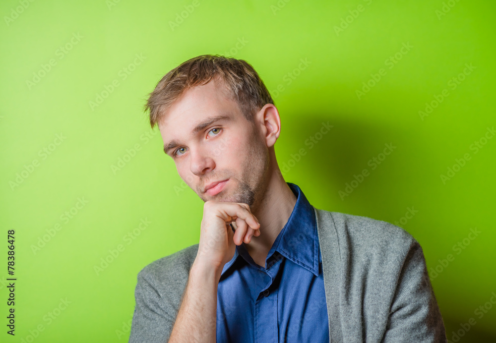 Young man chin resting on his hands with an intent sincere expression Young man chin resting on his hands with an intent sincere expression
