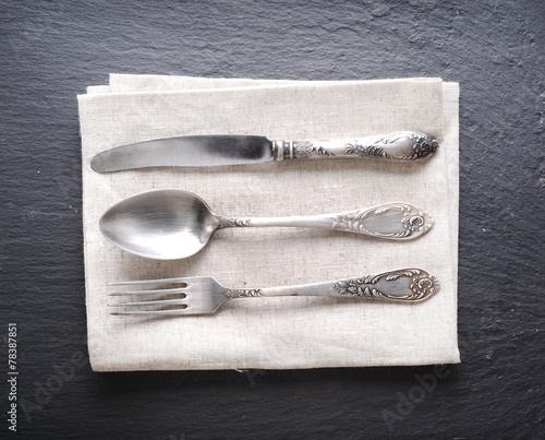 Silver cutlery on a dark grey background. photo