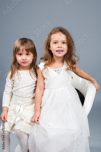 Two little funny and laughing girl in white clothes