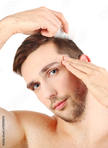 Handsome young man combing ...