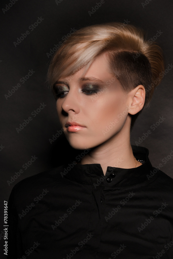 Blonde girl with a short stylish haircut on a dark background Blonde girl with a short stylish haircut on a dark background