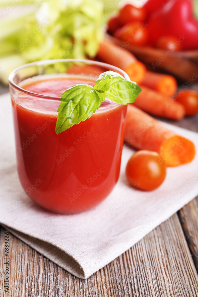 Glass of tomato juice with vegetables on wooden table close up Glass of tomato juice with vegetables on wooden table close up