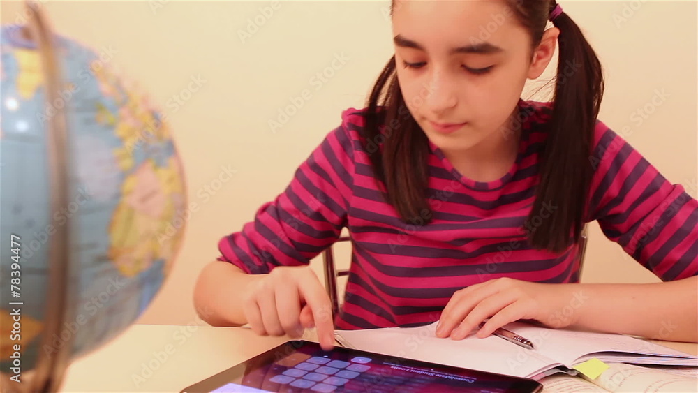 Schoolgirl doing her homework with digital tablet Schoolgirl doing her homework with digital tablet
