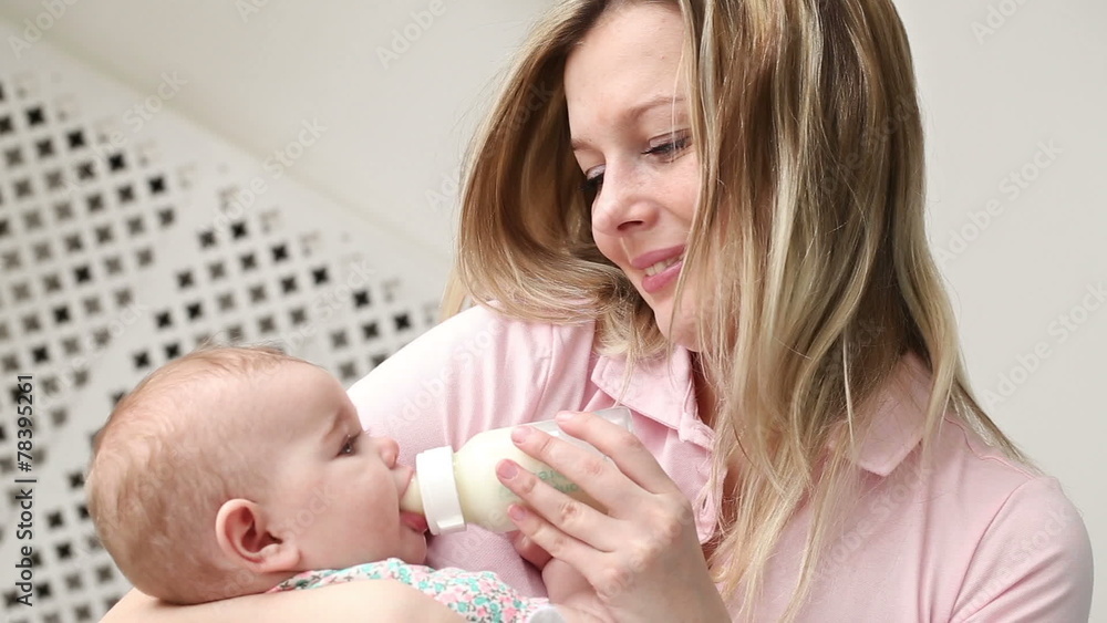 young mother feeding baby bottle young mother feeding baby bottle