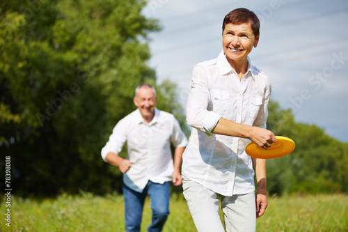 Frau und Mann spielen mit Frisbee im Sommer