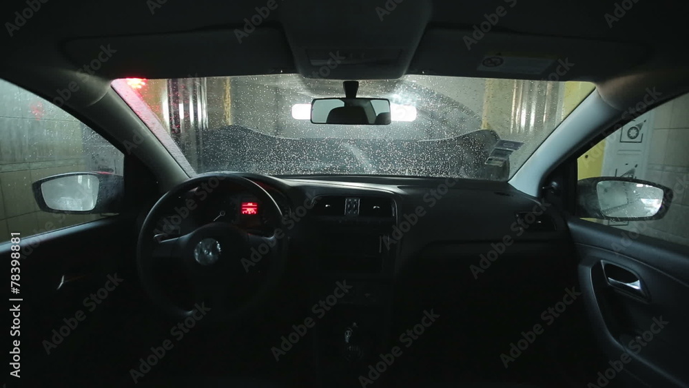Automatic car wash. Roller soaping and scrubbing the windshield Automatic car wash. Roller soaping and scrubbing the windshield