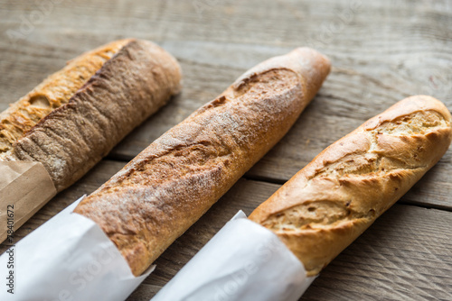 Three baguettes on the wooden background