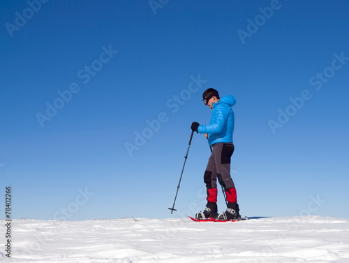 The man in snowshoes in the mountains.