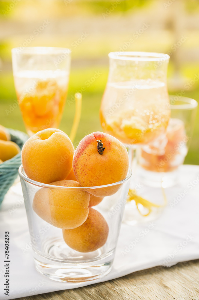 Ripe apricots in glass, drinks and sunny garden Ripe apricots in glass, drinks and sunny garden