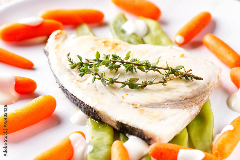 Swordfish grilled with mixed vegetables and yogurt sauce.