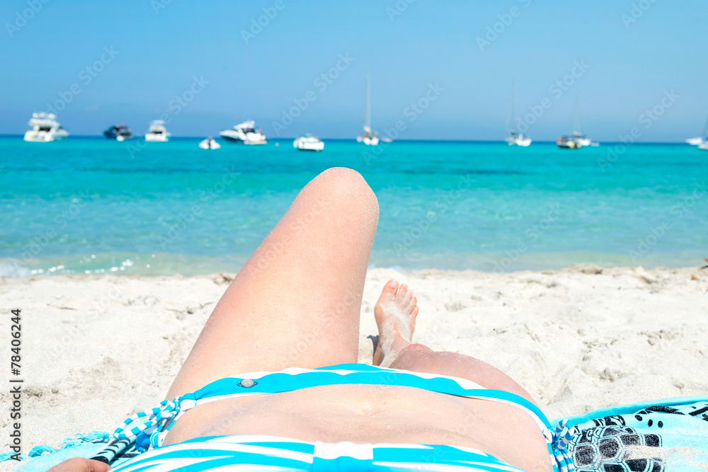 Woman sunbathing on the white beach of Saleccia Corsica, France