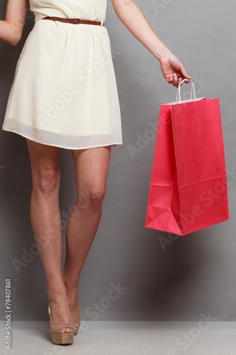 Woman holding red paper shopping bags