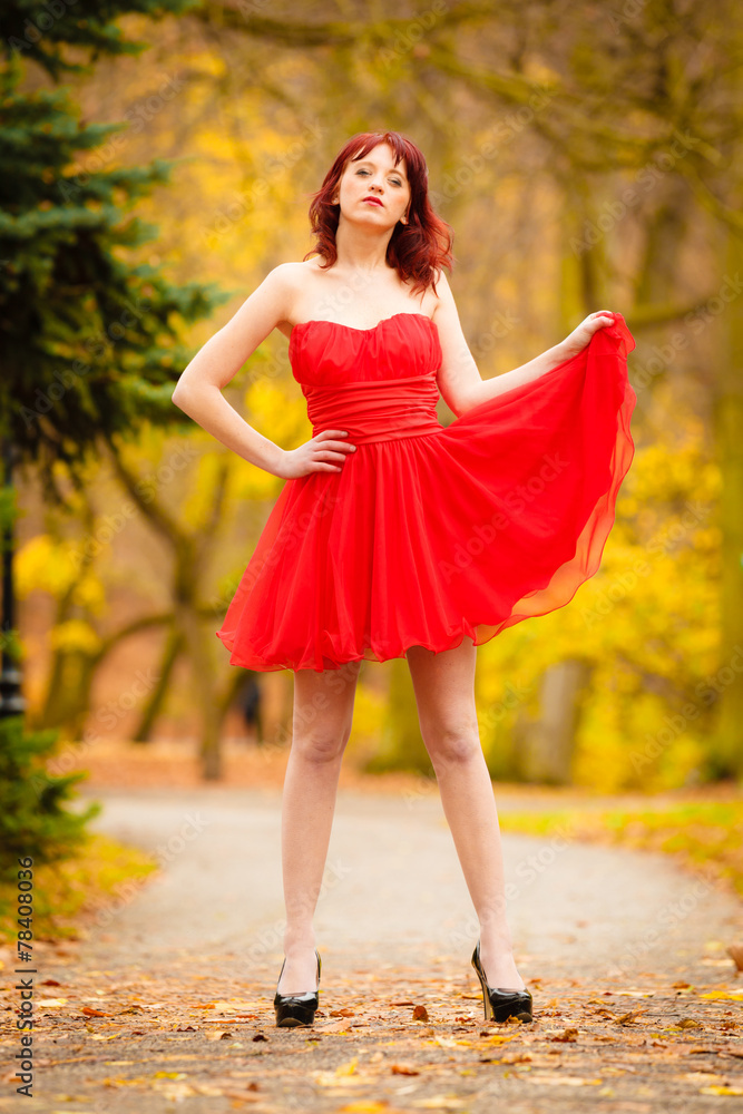 Fashion woman red dress relaxing walking in park Fashion woman red dress relaxing walking in park