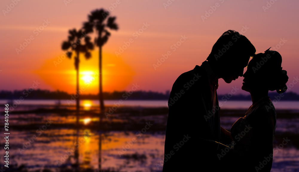 Silhouette couple kissing over sunset