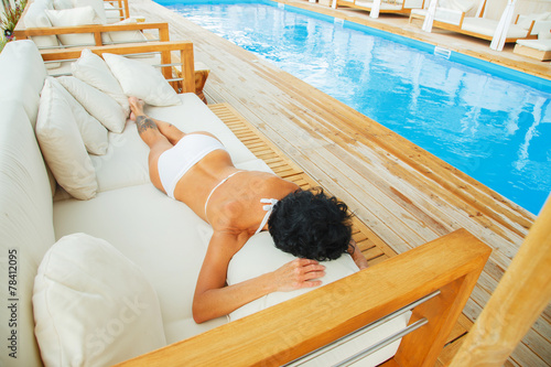 Middle age woman lies on a sofa. photo