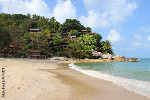 beautiful tropical beach and bungalows on rocky hill © monstersparrow
