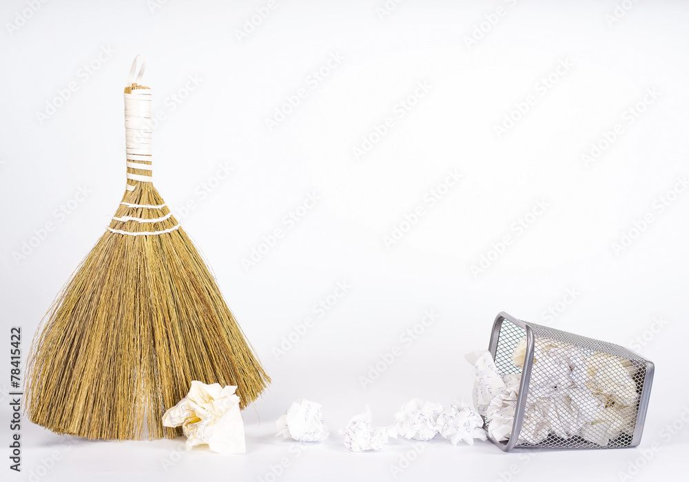 isolated besom and wastebasket full of color waste paper isolated besom and wastebasket full of color waste paper