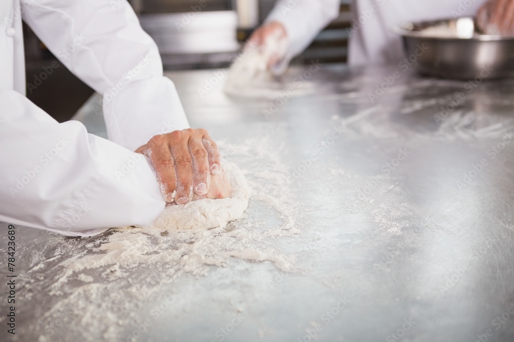 Close up of bakers kneading dough at counter Close up of bakers kneading dough at counter