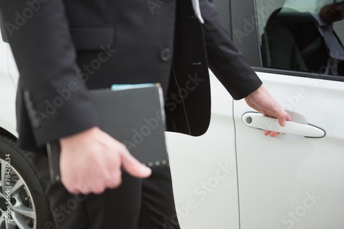 Businessman holding a car door handles © WavebreakMediaMicro