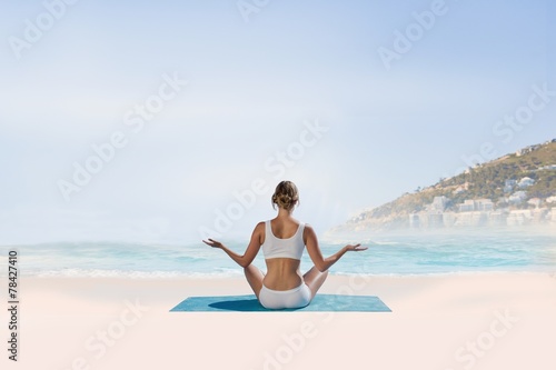 Composite image of fit woman sitting in lotus pose