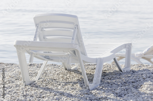 White plastic loungers to relax on beach