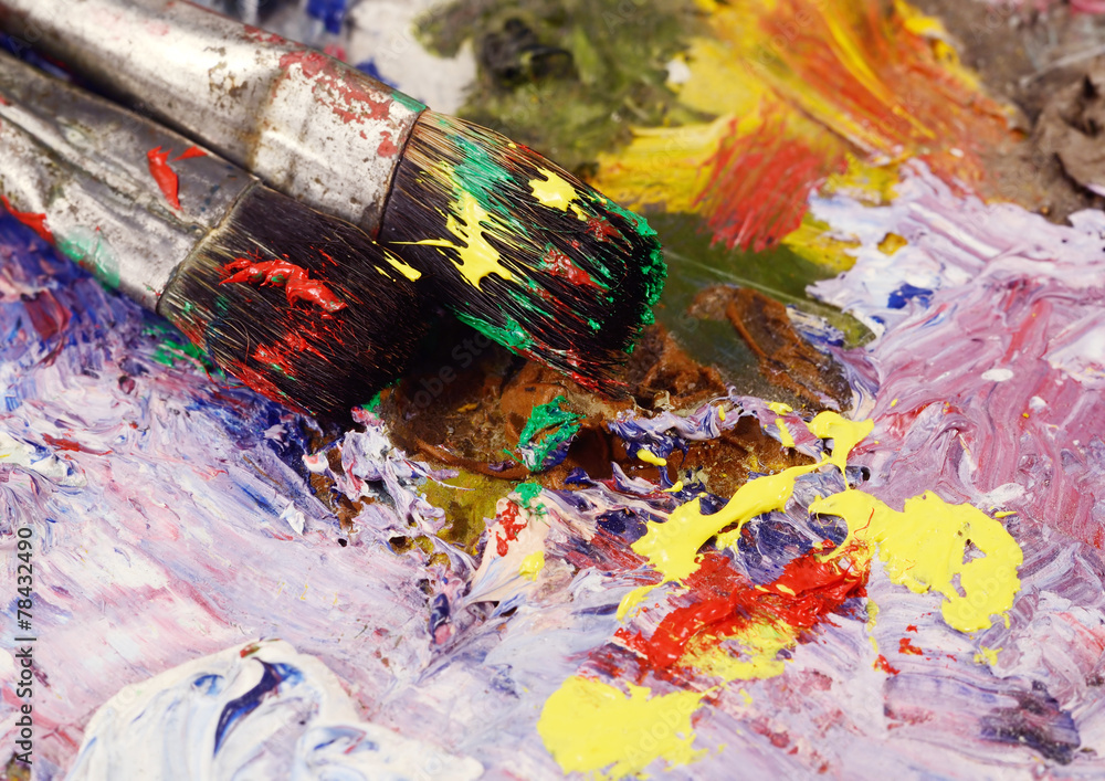 Art still life - two paintbrushes and dirty palette with colourf Art still life - two paintbrushes and dirty palette with colourf