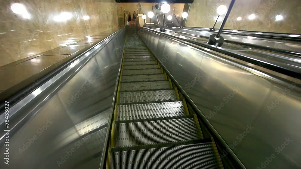 Escalator carries commuters down to the metro station. HD Escalator carries commuters down to the metro station. HD