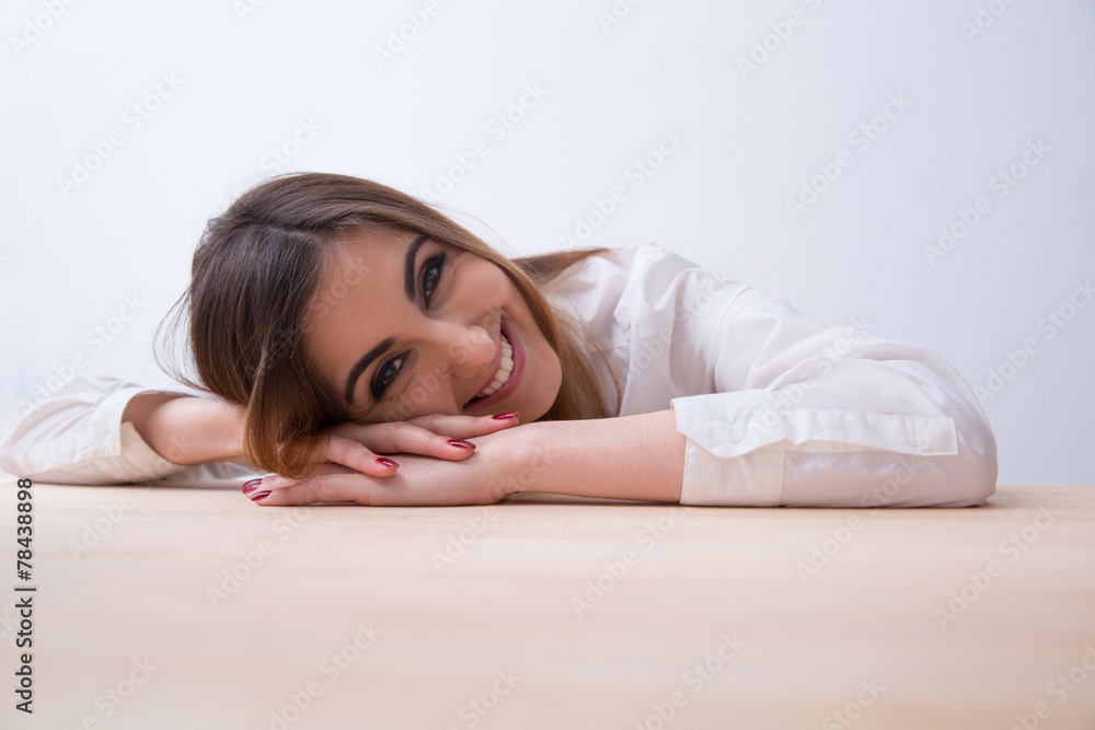 Portrait of a young smiling woman lying on the table Portrait of a young smiling woman lying on the table