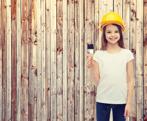 smiling little girl in helmet with paint roller photo