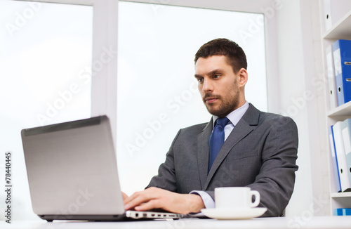 businessman with laptop typing in office