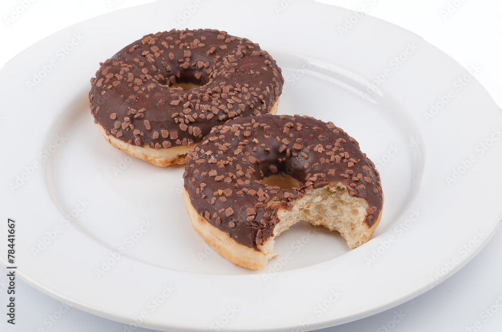 Two donuts with chocolate glaze which one is bitten served on a